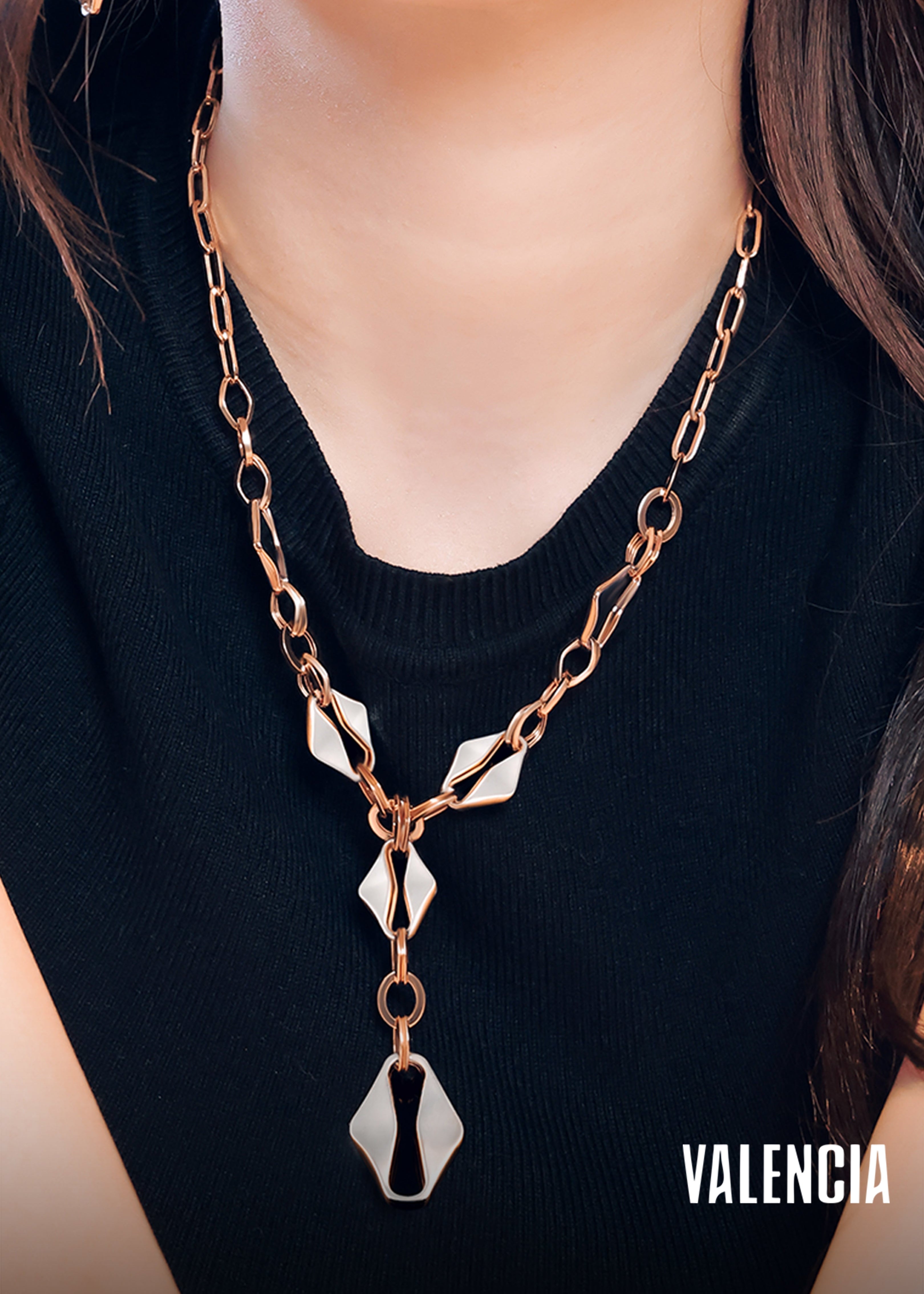 Necklace with geometric pendants on a black background, featuring the brand 'Valencia'.